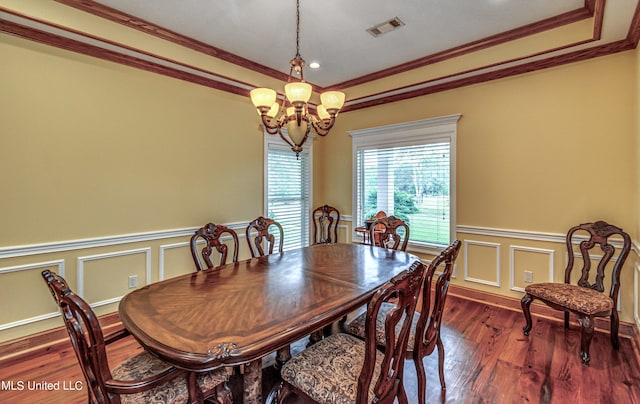 dining room featuring a notable chandelier, ornamental molding, and dark hardwood / wood-style flooring