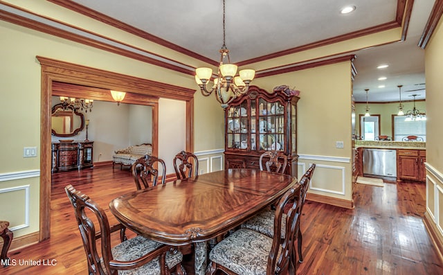 dining area featuring a notable chandelier, ornamental molding, and dark hardwood / wood-style flooring