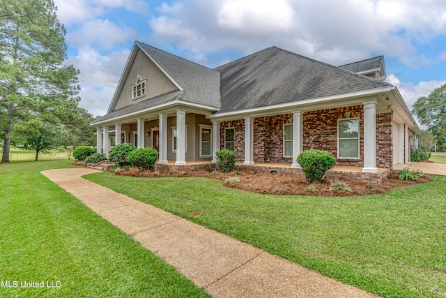 view of front of home featuring covered porch, a garage, and a front lawn