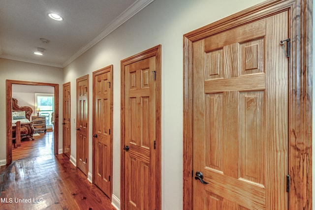 corridor featuring ornamental molding and dark hardwood / wood-style flooring