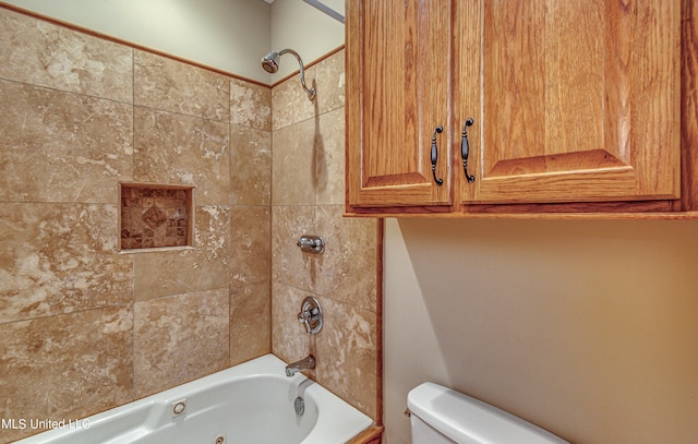 bathroom with tiled shower / bath combo and toilet