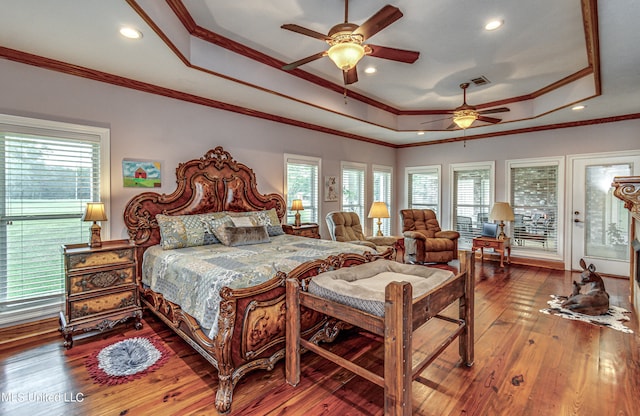 bedroom with crown molding, wood-type flooring, a tray ceiling, and ceiling fan