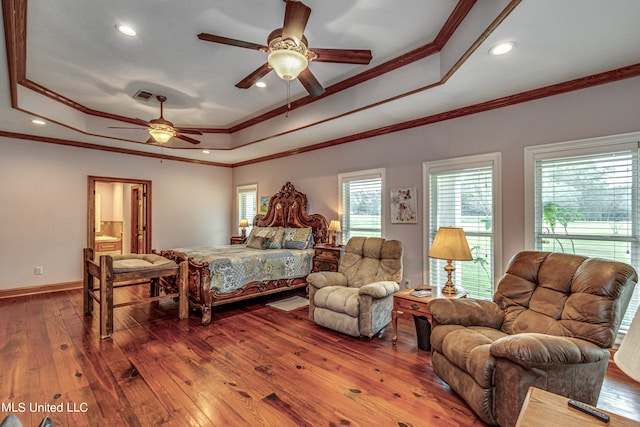 bedroom with wood-type flooring, a tray ceiling, and ceiling fan