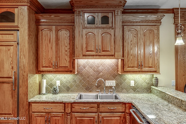 kitchen featuring backsplash, dishwasher, sink, and hanging light fixtures