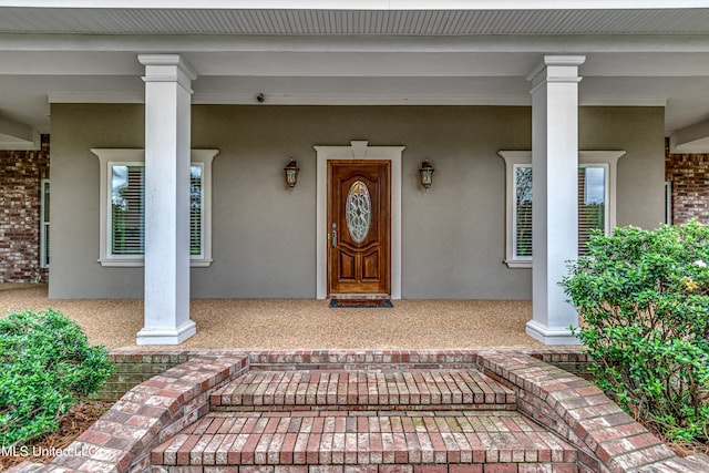 view of exterior entry with covered porch