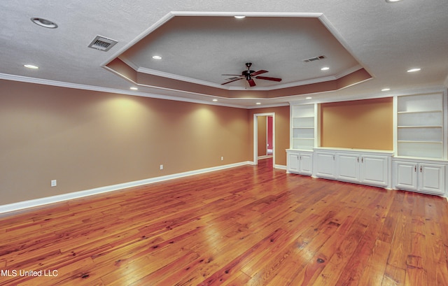 unfurnished living room featuring ornamental molding, a tray ceiling, and light hardwood / wood-style floors