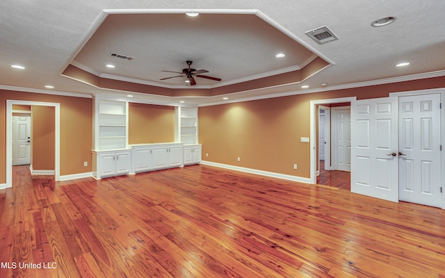 unfurnished living room with a tray ceiling and wood-type flooring