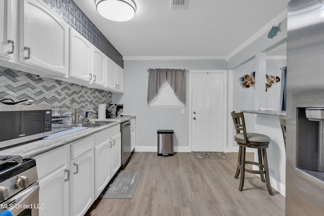 kitchen featuring light hardwood / wood-style floors, white cabinets, stainless steel appliances, and sink