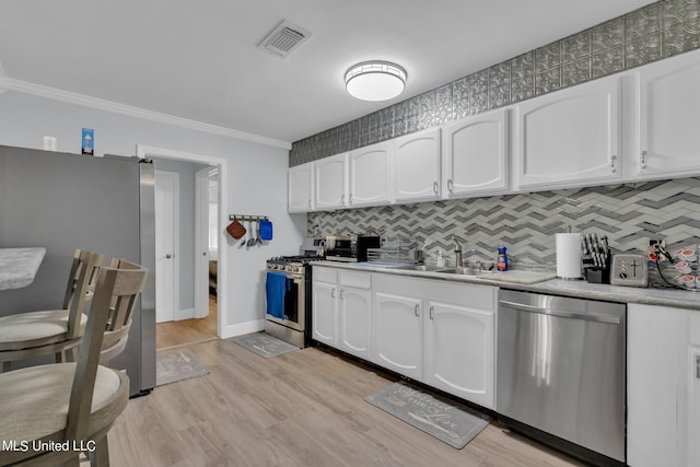 kitchen featuring light hardwood / wood-style flooring, stainless steel appliances, sink, crown molding, and white cabinets