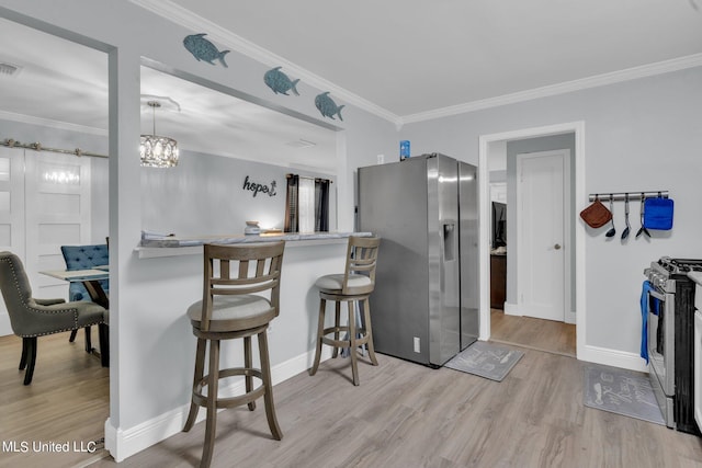 kitchen featuring light hardwood / wood-style floors, crown molding, stainless steel appliances, and a breakfast bar area