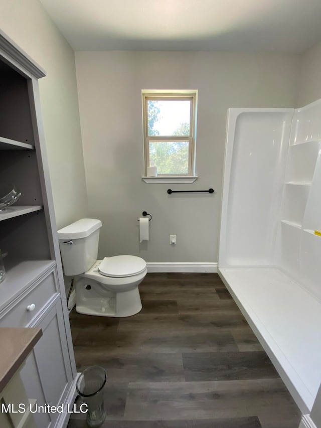 bathroom featuring toilet, hardwood / wood-style flooring, and walk in shower