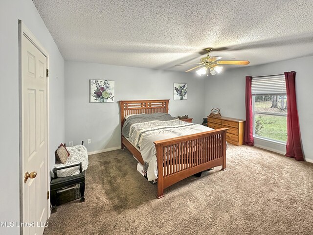 bedroom featuring a ceiling fan, carpet flooring, a textured ceiling, and baseboards