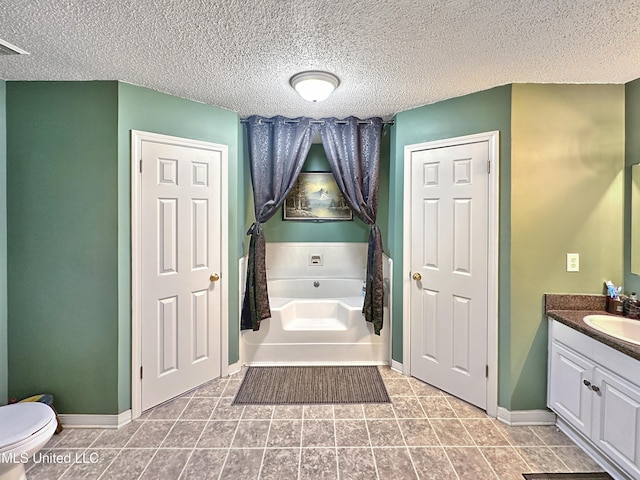 full bath with a garden tub, toilet, a textured ceiling, vanity, and baseboards