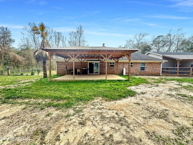 back of house featuring a yard, brick siding, a patio area, and fence