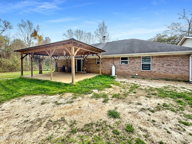 back of house with a patio, brick siding, driveway, a gazebo, and a carport