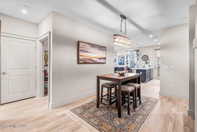 dining space featuring a notable chandelier and light hardwood / wood-style flooring