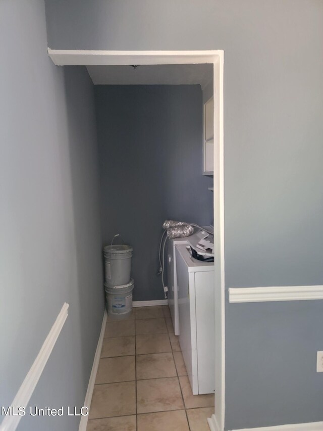 laundry room with independent washer and dryer and light tile patterned floors