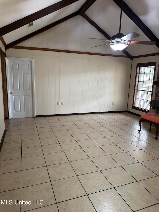 tiled empty room with wooden walls, vaulted ceiling with beams, and ceiling fan