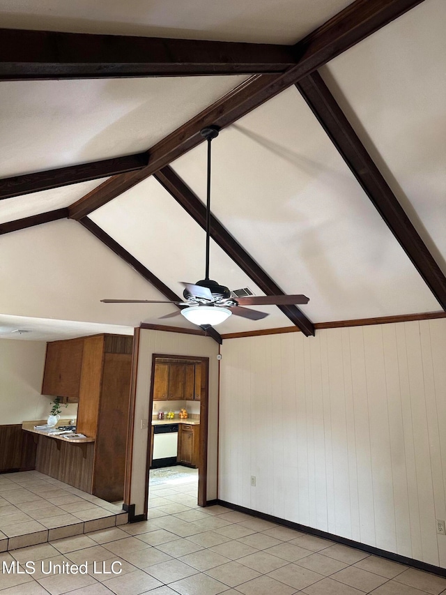 unfurnished living room with wooden walls, lofted ceiling with beams, light tile patterned floors, and ceiling fan