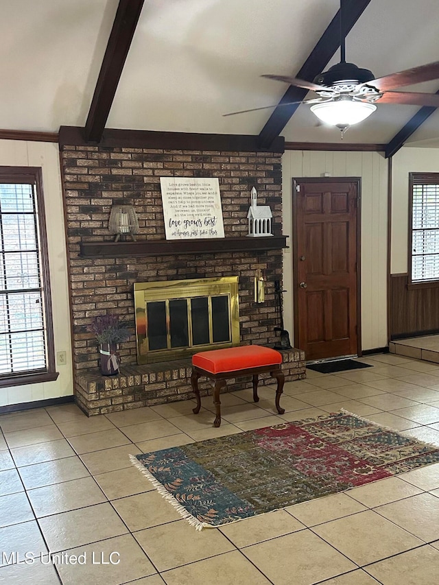 tiled entryway featuring ceiling fan, lofted ceiling with beams, wooden walls, and a fireplace