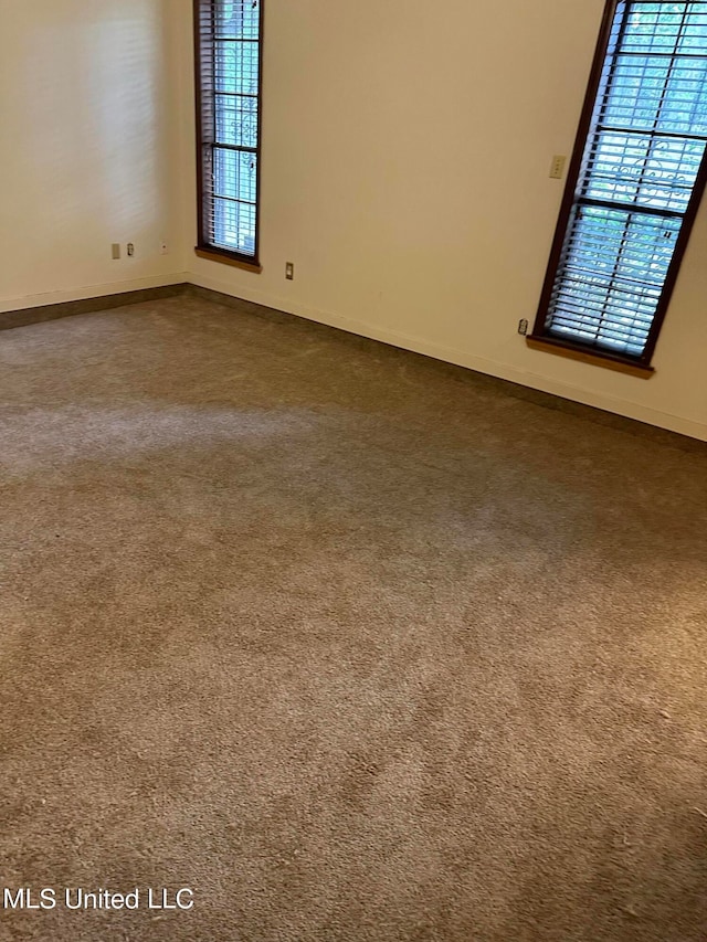 empty room with a wealth of natural light and carpet floors