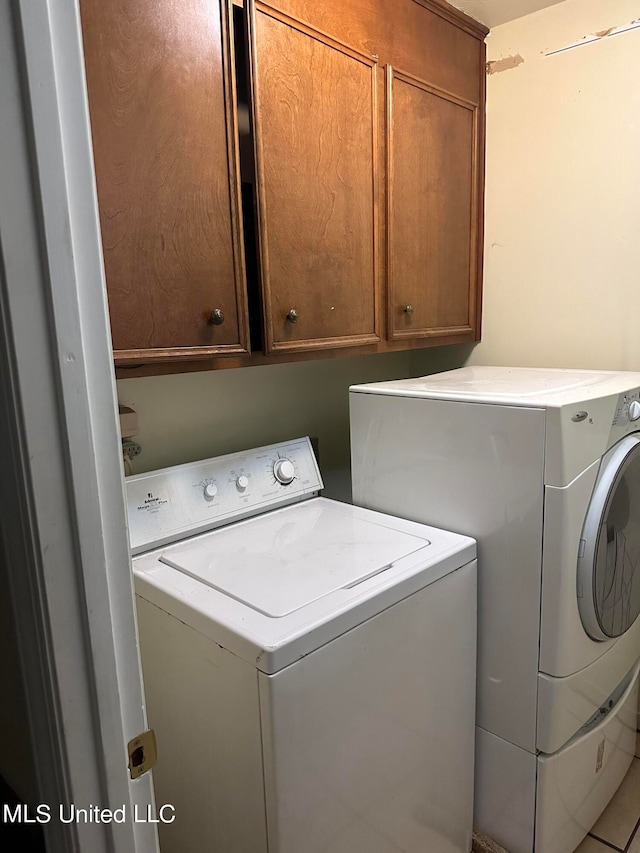 washroom with cabinets, tile patterned floors, and separate washer and dryer