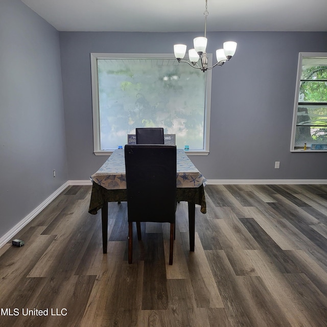 dining area featuring dark wood-type flooring and a chandelier