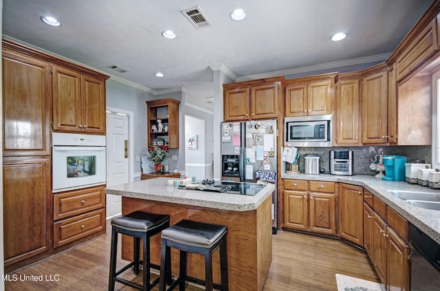 506 Ridge Cir, Brandon, MS 39047 - kitchen with stainless steel appliances, light wood-type flooring, a kitchen island, open shelves, and a kitchen bar