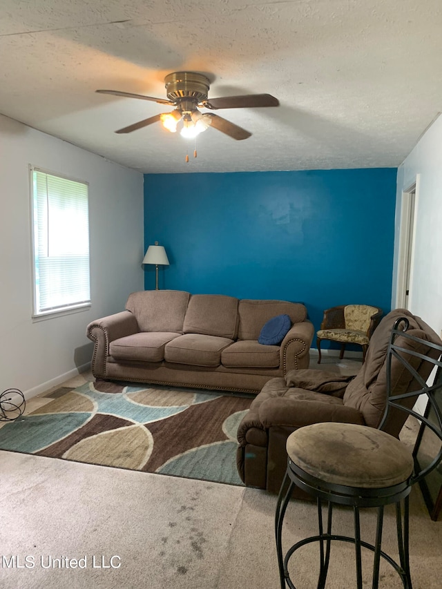 carpeted living room with a textured ceiling and ceiling fan