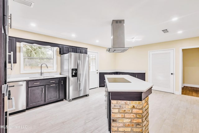 kitchen featuring light wood-type flooring, stainless steel appliances, sink, a center island, and range hood