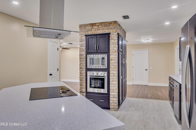 kitchen featuring light stone countertops, stainless steel appliances, light hardwood / wood-style flooring, and extractor fan