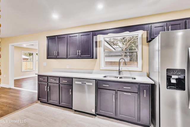 kitchen with sink, light wood-type flooring, and appliances with stainless steel finishes