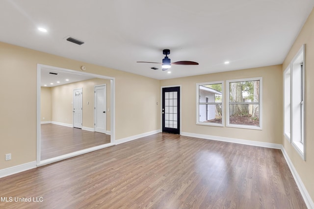 empty room with ceiling fan and light hardwood / wood-style flooring