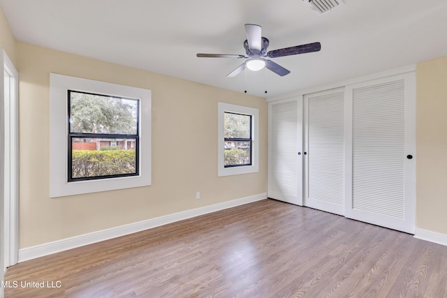 unfurnished bedroom with multiple windows, a closet, light hardwood / wood-style flooring, and ceiling fan