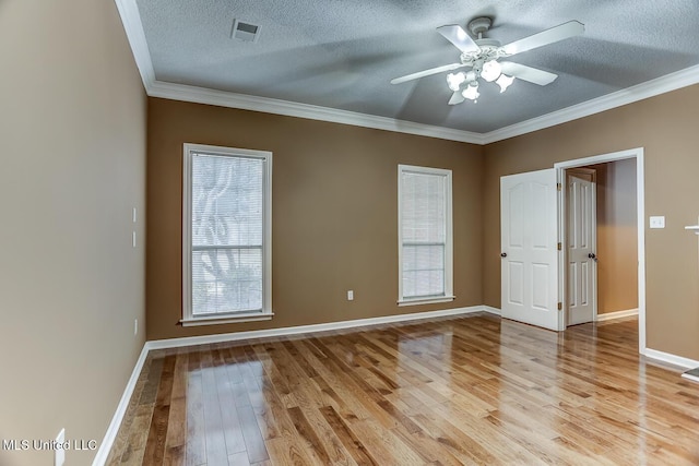 spare room with crown molding, ceiling fan, a textured ceiling, and light wood-type flooring