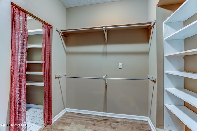 walk in closet featuring light hardwood / wood-style flooring