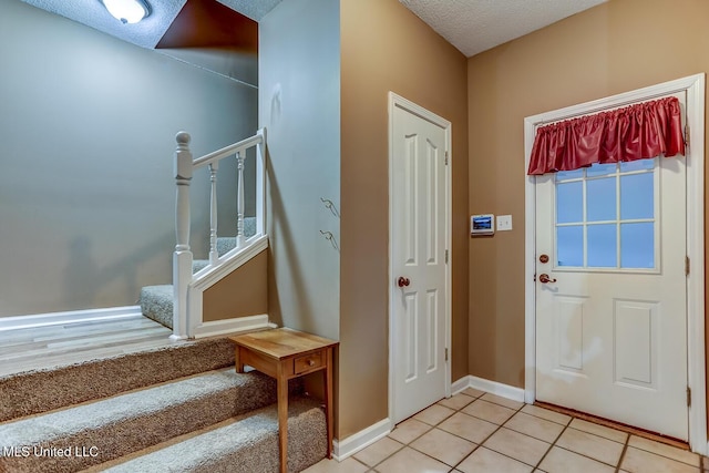 tiled foyer entrance with a textured ceiling