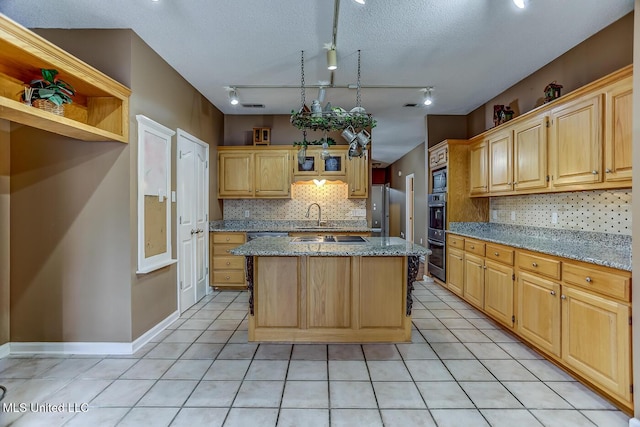 kitchen featuring stainless steel fridge, light stone countertops, a center island, and rail lighting