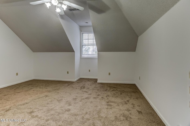 additional living space with carpet, ceiling fan, a textured ceiling, and vaulted ceiling