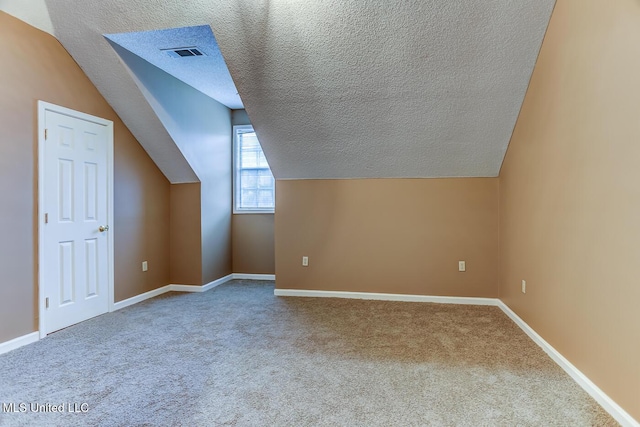 bonus room with carpet floors, a textured ceiling, and vaulted ceiling