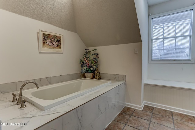 bathroom with a textured ceiling, a relaxing tiled tub, and lofted ceiling