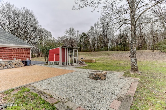 view of yard with a fire pit and an outbuilding