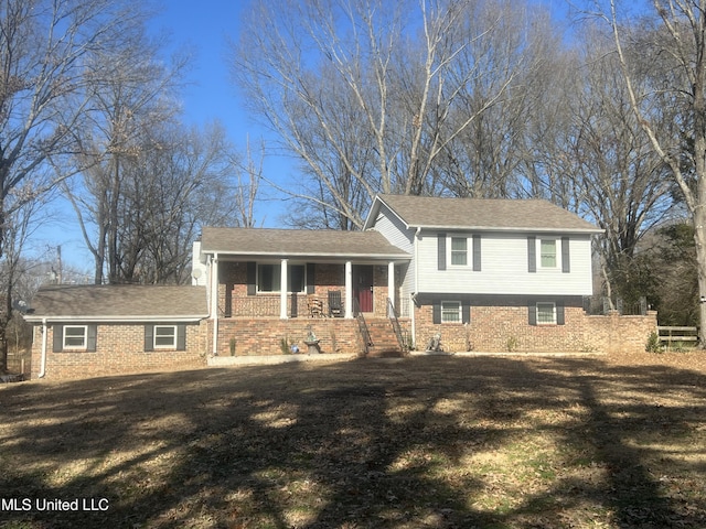 split level home with a front lawn and a porch