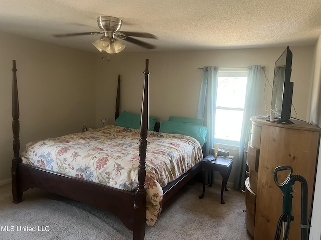 carpeted bedroom featuring ceiling fan and a textured ceiling