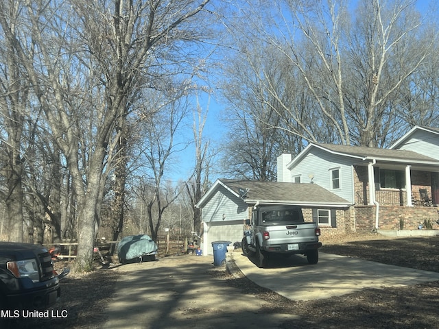 view of side of home featuring a garage and a porch