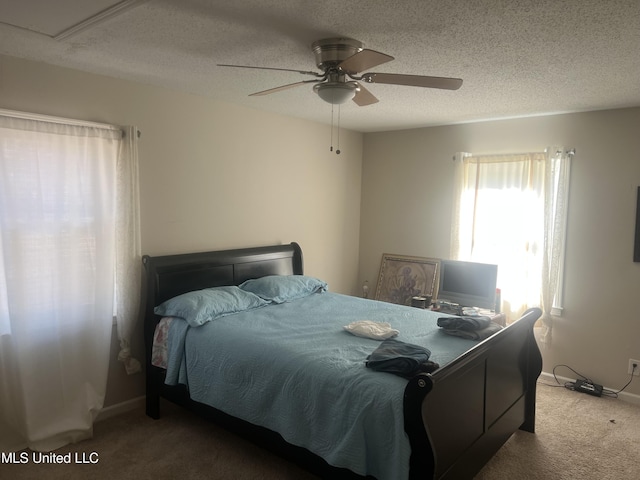 carpeted bedroom featuring ceiling fan and a textured ceiling