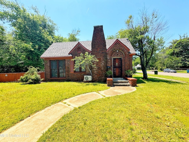 340 Elm Ave, Clarksdale, MS 38614 - tudor-style house with french doors, brick siding, a chimney, and a shingled roof