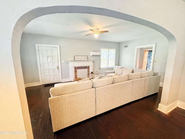 340 Elm Ave, Clarksdale, MS 38614 - living area with arched walkways, a wall unit AC, dark wood-style floors, ceiling fan, and baseboards