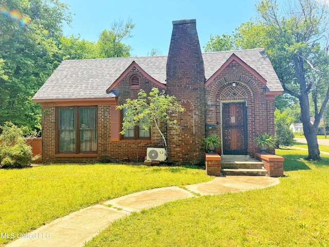 340 Elm Ave, Clarksdale, MS 38614 - tudor-style house featuring french doors, brick siding, a chimney, and a front lawn