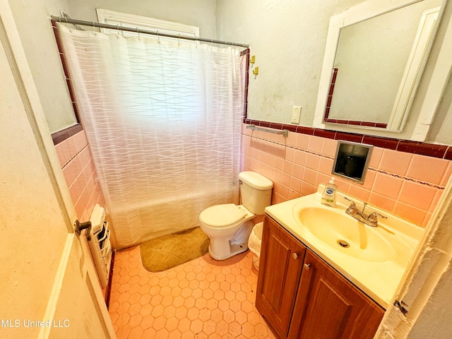 340 Elm Ave, Clarksdale, MS 38614 - bathroom with tile walls, vanity, toilet, shower / bath combo, and wainscoting